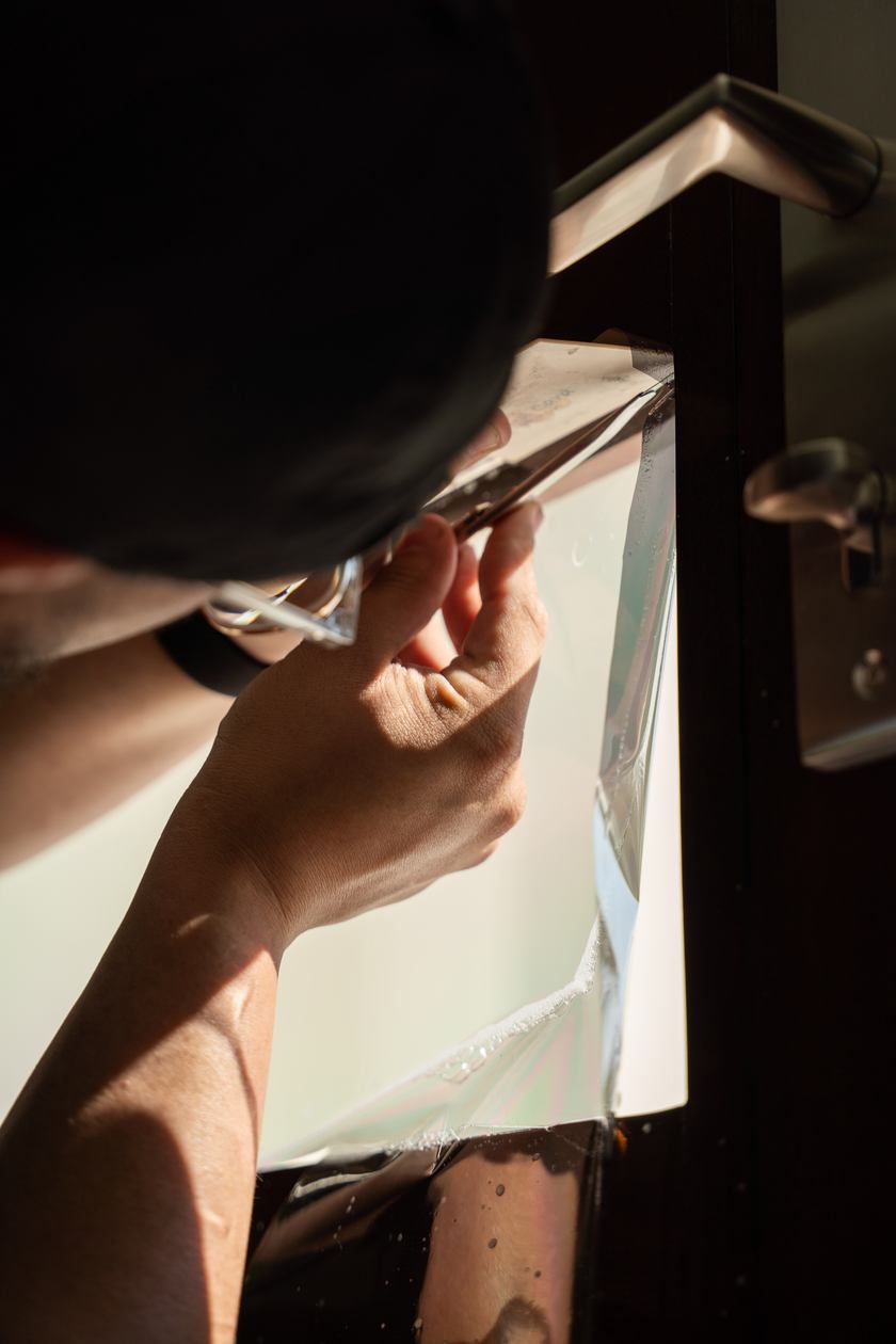 Blade trimming protective film flush to a door panel
