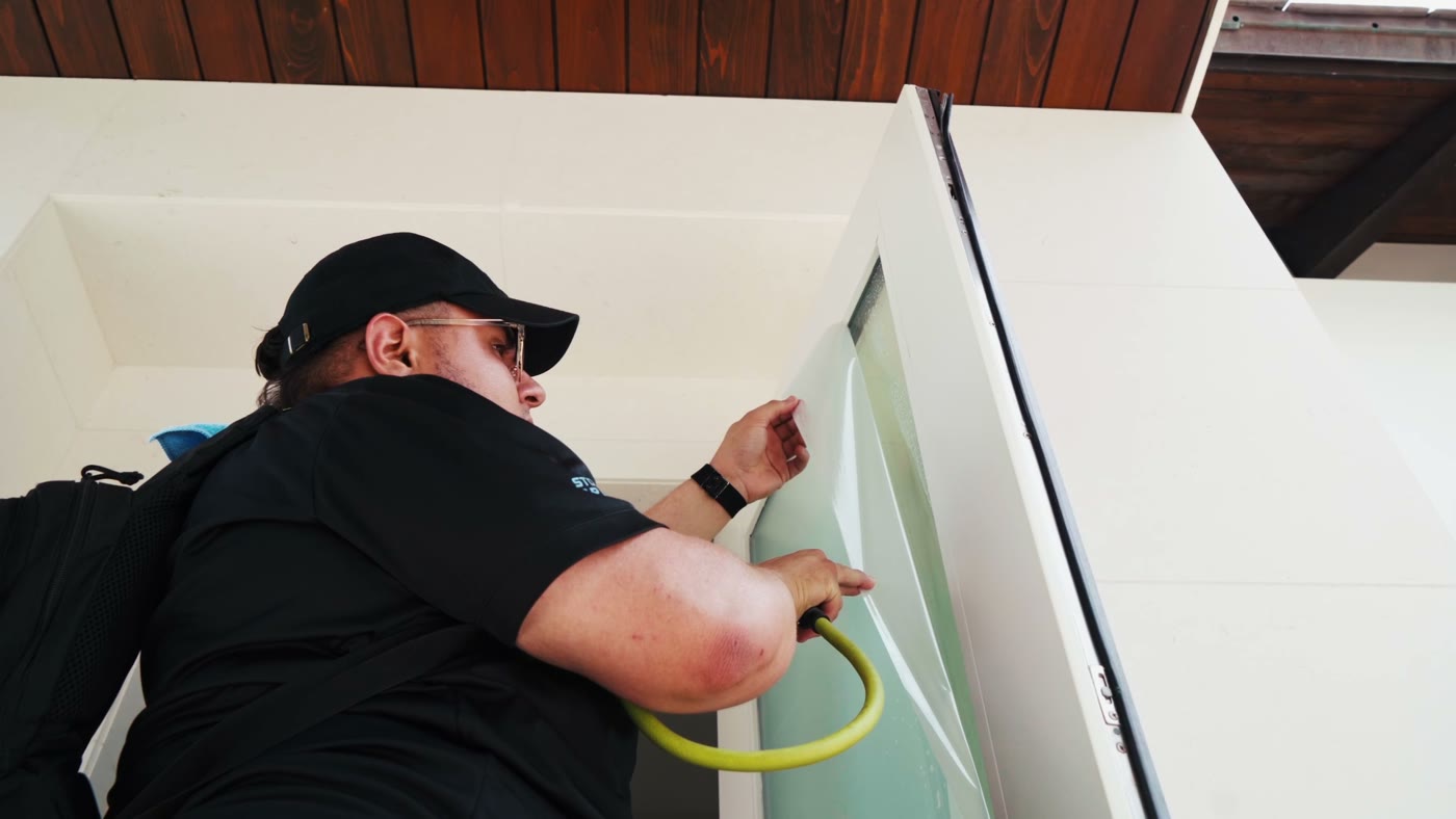 Installer finishing film at the edge of a wall panel